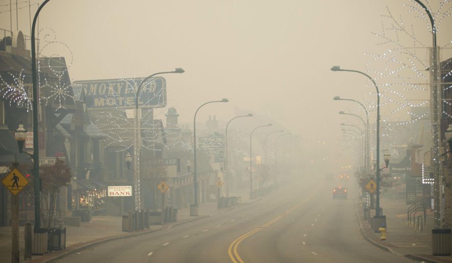 FILE - In a Monday, Nov. 28, 2016 file photo, thick smoke from area forest fires looms in Gatlinburg, Tenn., as several areas are being evacuated as a result of fires in and around Great Smoky Mountains National Park. The National Park Service announced Thursday, Aug. 31, 2017, that Great Smoky Mountains National Park will receive a $2.5 million upgrade to its radio communications systems in response to the fire. (Brianna Paciorka/Knoxville News Sentinel via AP)