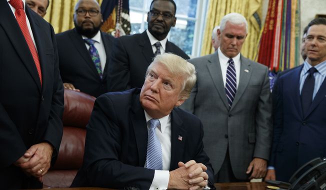 President Donald Trump listens as faith leaders speak after he signed a proclamation for a national day of prayer to occur on Sunday, Sept. 3, 2017, in the Oval Office of the White House, Friday, Sept. 1, 2017, in Washington. (AP Photo/Evan Vucci)