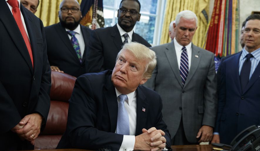President Donald Trump listens as faith leaders speak after he signed a proclamation for a national day of prayer to occur on Sunday, Sept. 3, 2017, in the Oval Office of the White House, Friday, Sept. 1, 2017, in Washington. (AP Photo/Evan Vucci)
