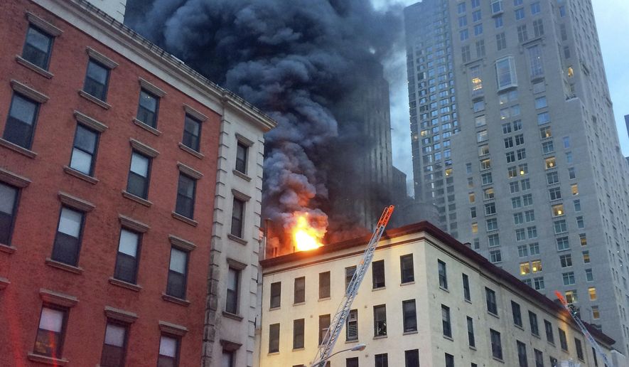 Fire and smoke shoot through roof of a five-story building, in New York, Friday, Sept. 1, 2017. The building has retail space on the first floor and apartments above, in Manhattan's Tribeca neighborhood. (AP Photo/David Caruso)