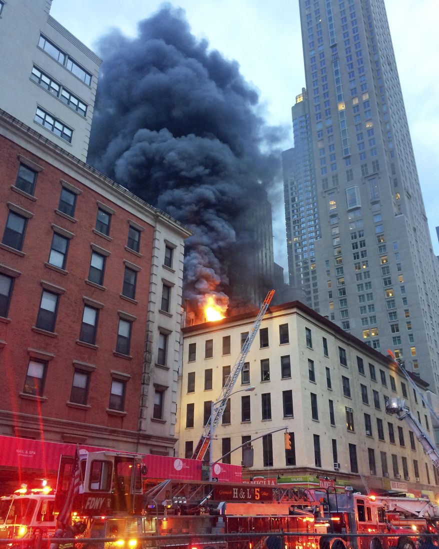 Fire and smoke shoot through roof of a five-story building, in New York, Friday, Sept. 1, 2017. The building has retail space on the first floor and apartments above, in Manhattan's Tribeca neighborhood. (AP Photo/David Caruso)