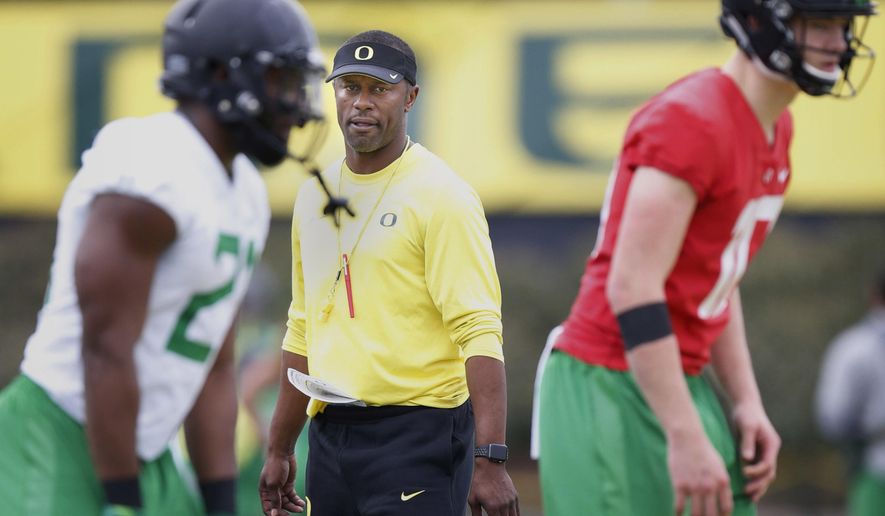 FILE - In this April 5,2017, file photo, Oregon's first year head coach Willie Taggart watches his running back Royce Freeman, left, and quarterback Justin Herbert as they run through a drill during the first day of spring practice for the Ducks in Eugene, Ore. The first-year coach and his Oregon Ducks open the season at home against Southern Utah on Saturday, Sept. 2, 2017, and Taggart admits he's a little bit nervous.(Andy Nelson/The Register-Guard via AP, File)