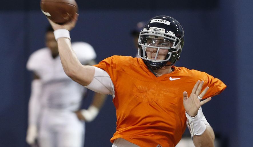 FILE - This Thursday April 6, 2017, file photo shows Virginia quarterback Kurt Benkert throwing a pass during a spring football practice at their indoor facility in Charlottesville, Va. A lingering shadow still looms over Virginia following the tragedy that hit the campus and Charlottesville community three weeks ago. So the university is using sports to promote inclusion, and the effort begins Saturday when Virginia plays host to William & Mary in the season-opener for both football programs. Benkert knows the easiest way for he and his teammates to do their part: win the game. (AP Photo/Steve Helber, File)
