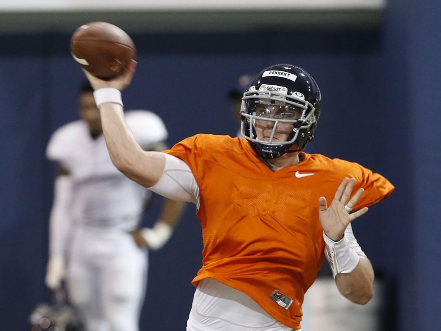 FILE - This Thursday April 6, 2017, file photo shows Virginia quarterback Kurt Benkert throwing a pass during a spring football practice at their indoor facility in Charlottesville, Va. A lingering shadow still looms over Virginia following the tragedy that hit the campus and Charlottesville community three weeks ago. So the university is using sports to promote inclusion, and the effort begins Saturday when Virginia plays host to William & Mary in the season-opener for both football programs. Benkert knows the easiest way for he and his teammates to do their part: win the game. (AP Photo/Steve Helber, File)