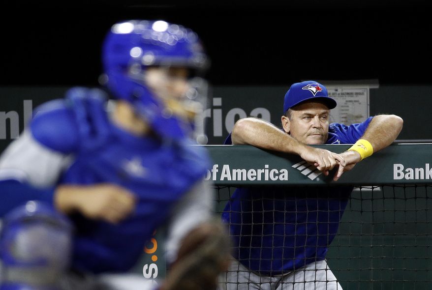 Toronto Blue Jays manager John Gibbons leans against the dugout rail beyond Blue Jays catcher Raffy Lopez during the third inning of a baseball game against the Baltimore Orioles in Baltimore, Friday, Sept. 1, 2017. Baltimore won 1-0 in 13 innings. (AP Photo/Patrick Semansky)