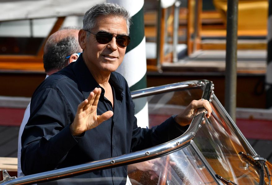 Actor George Clooney waves to photographers as he arrives on a motorboat during the 74th edition of the Venice Film Festival, in Venice, Italy, Saturday, Sept. 2, 2017. (Ettore Ferrari/ANSA via AP)