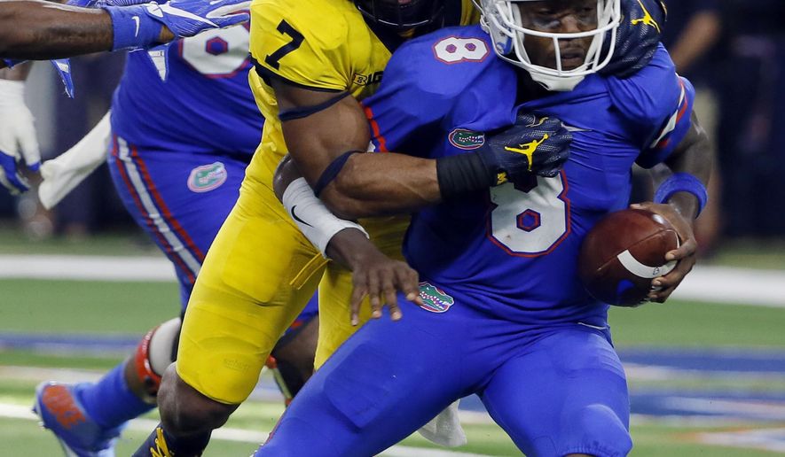 Florida quarterback Malik Zaire (8) is sacked by Michigan safety Khaleke Hudson (7) in the second half of an NCAA college football game, Saturday, Sept. 2, 2017, in Arlington, Texas. (AP Photo/Tony Gutierrez)