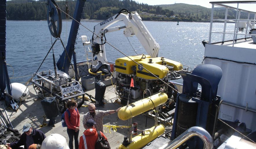 In this Friday, Aug. 25, 2017 photo, crews work at the stern of the EV Nautilus near Neah Bay, Wash., in preparation for dives by the remotely-operated vehicles Argus, left, and Hercules in the Juan de Fuca Canyon in the Olympic Coast National Marine Sanctuary. From one underwater canyon to the next, the EV Nautilus is shedding new light on the Olympic Coast National Marine Sanctuary. (Rob Ollikainen/The Peninsula Daily News via AP)