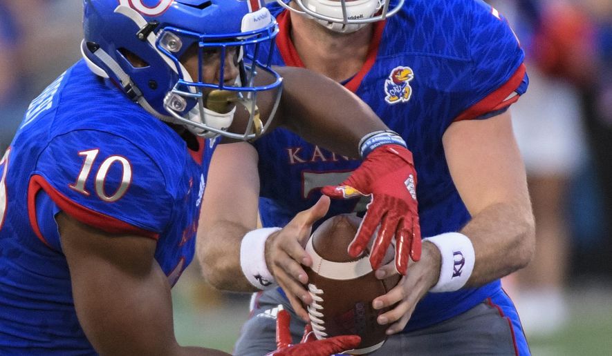 Kansas Jayhawks quarterback Peyton Bender (7) hands off to Kansas Jayhawks running back Khalil Herbert (10) during the first half of an NCAA college football game in Lawrence, Kan., Saturday, Sept. 2, 2017. (AP Photo/Reed Hoffmann)