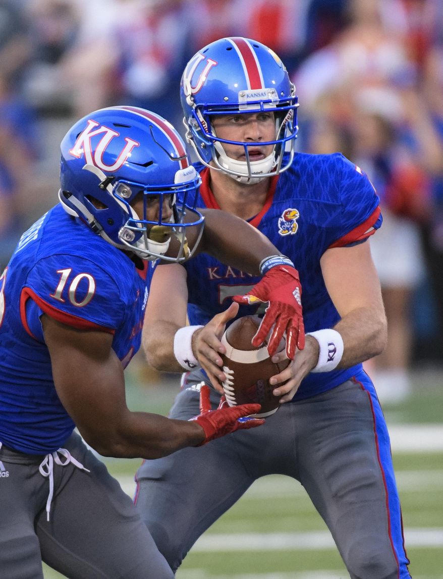 Kansas Jayhawks quarterback Peyton Bender (7) hands off to Kansas Jayhawks running back Khalil Herbert (10) during the first half of an NCAA college football game in Lawrence, Kan., Saturday, Sept. 2, 2017. (AP Photo/Reed Hoffmann)