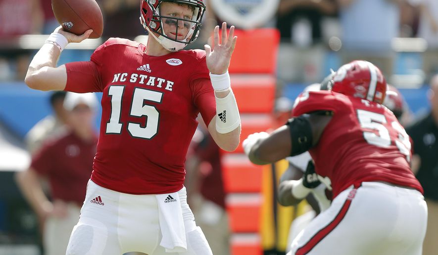 North Carolina State's Ryan Finley (15) aims a pass against the South Carolina defense during the first half of a college football game in Charlotte, N.C., Saturday, Sept. 2, 2017. (AP Photo/Bob Leverone)