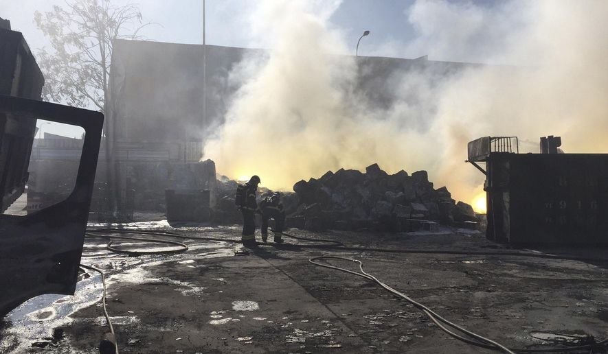In this image released by 112 Comunidad de Madrid, the Madrid emergency services on Saturday Sept. 2, 2017, firefighters work at the scene of a fire which produced a toxic cloud in the south of Madrid, Spain. Spanish emergency services have warned residents in southern Madrid to remain in their homes to avoid a toxic cloud produced by a fire in a nearby industrial building. One man has been taken to hospital to treat burns, while a nearby hotel and industrial building have been evacuated. (112 Comunidad de Madrid, via AP)