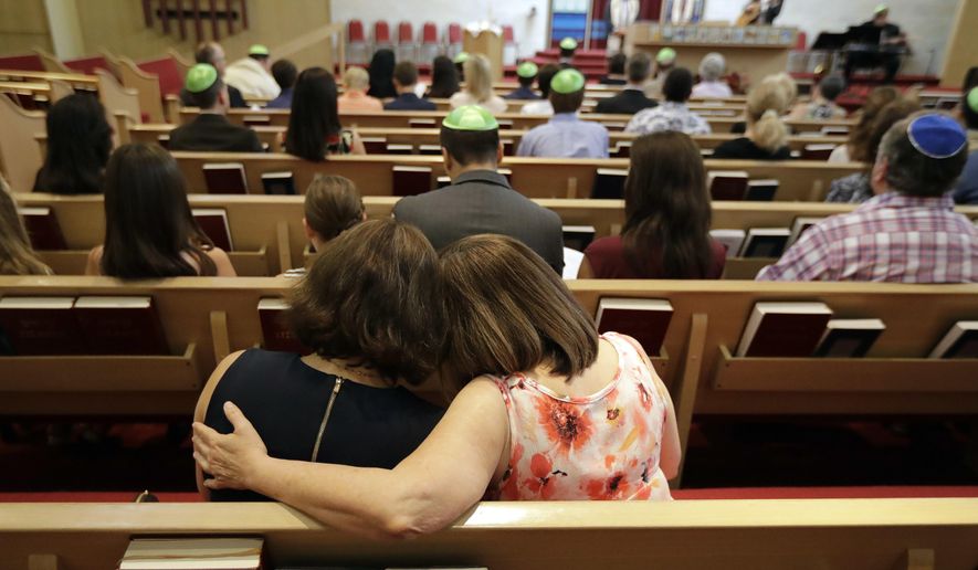 Debbie Uzick, right, puts her arm around Natalie Hausman-Weiss during a Bar Mitzvah on Saturday, Sept. 2, 2017, in Houston. Both of their homes were flooded in the aftermath of Harvey. (AP Photo/David J. Phillip)