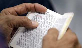 A man holds a Bible during while attending church services in Cypress, Texas. (Associated Press) **FILE**