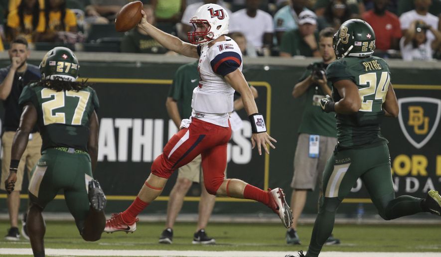 Liberty quarterback Stephen Calvert, center, scores past Baylor cornerback Verkedric Vaughns, left, and defensive back Jalen Pitre, right, in the second half of an NCAA college football game, Saturday, Sept. 2, 2017, in Waco, Texas. (Rod Aydelotte/Waco Tribune Herald, via AP)