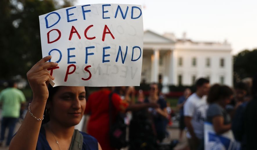 A woman holds up a sign that reads &quot;Defend DACA Defend TPS&quot; during a rally supporting Deferred Action for Childhood Arrivals, or DACA, outside the White House in Washington, Monday, Sept. 4, 2017. TPS stands for &quot;Temporary Protected Status.&quot; A plan President Donald Trump is expected to announce Tuesday for young immigrants brought to the country illegally as children was embraced by some top Republicans on Monday and denounced by others as the beginning of a &quot;civil war&quot; within the party. (AP Photo/Carolyn Kaster)
