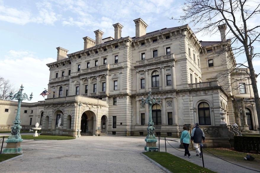 FILE - In this Dec. 1, 2014, file photo, visitors walk toward an entrance to The Breakers mansion in Newport, R.I. Visitors to the spectacular Gilded Age mansion are now being allowed to explore its depths with a new tour that shows off the domestic technology that helped make the 70-room, building state-of-the art when it was completed in 1895. (AP Photo/Steven Senne, File)