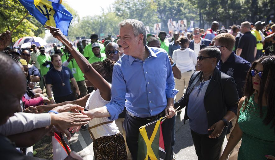 New York Mayor Bill de Blasio greets spectators at the West Indian Day Parade on Monday, Sept. 4, 2017, in the Brooklyn borough of New York. The parade, one of the largest celebrations of Caribbean culture in the U.S., is being held amid ramped-up security. (AP Photo/Kevin Hagen)