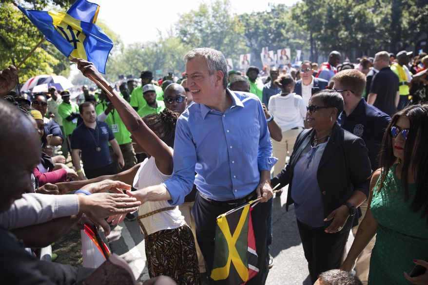 New York Mayor Bill de Blasio greets spectators at the West Indian Day Parade on Monday, Sept. 4, 2017, in the Brooklyn borough of New York. The parade, one of the largest celebrations of Caribbean culture in the U.S., is being held amid ramped-up security. (AP Photo/Kevin Hagen)