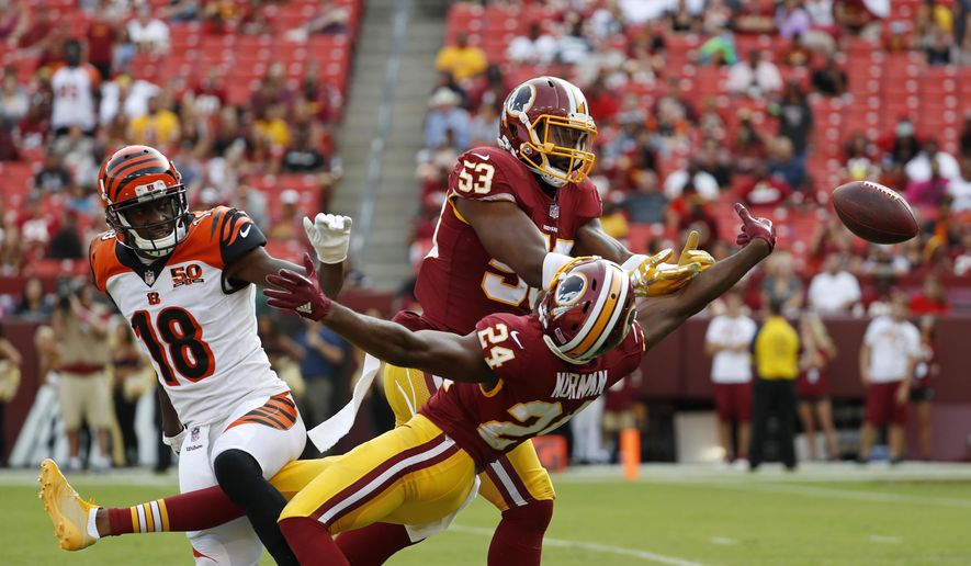 FILE - In this Aug. 27, 2017, file photo, Washington Redskins linebacker Zach Brown (53) and cornerback Josh Norman (24) break up a pass attempt to Cincinnati Bengals wide receiver A.J. Green (18) during a preseason NFL football game in Landover, Md. Defensive coordinator Greg Manusky’s more aggressive defense should allow Norman, an All-Pro cornerback in 2015 with Carolina, to make more big plays. (AP Photo/Alex Brandon, File) **FILE**