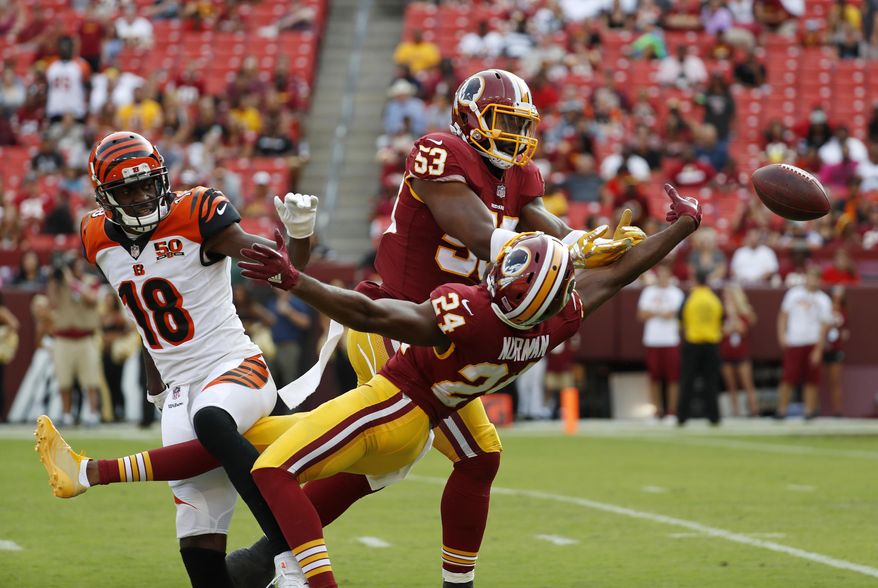 FILE - In this Aug. 27, 2017, file photo, Washington Redskins linebacker Zach Brown (53) and cornerback Josh Norman (24) break up a pass attempt to Cincinnati Bengals wide receiver A.J. Green (18) during a preseason NFL football game in Landover, Md. Defensive coordinator Greg Manusky’s more aggressive defense should allow Norman, an All-Pro cornerback in 2015 with Carolina, to make more big plays. (AP Photo/Alex Brandon, File) **FILE**