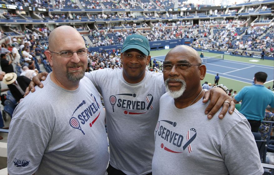 From left, military veterans Marc Spittler, Jon Atkins, and Henry Pruitt, all from Orlando, Fla., pose for a photo during a break in play during the fourth round of the U.S. Open tennis tournament, Monday, Sept. 4, 2017, in New York. (AP Photo/Jason Decrow)