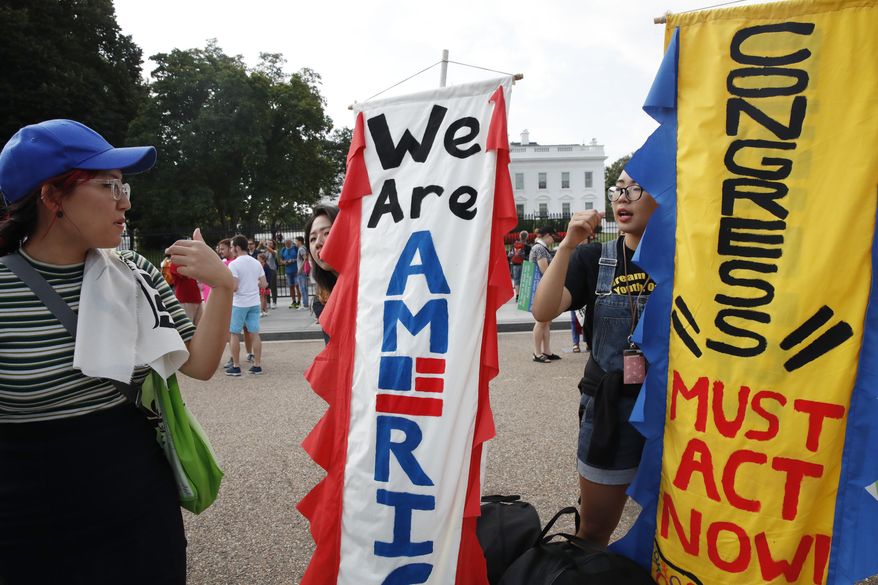 Yoon Kim, 32, of Los Angeles, right, holds a sign urging "Congress Must Act Now" as supporters of the Deferred Action for Childhood Arrivals program, know as DACA, rally outside of the White House, in Washington, Tuesday, Sept. 5, 2017. President Donald Trump will end a program that has protected hundreds of thousands of young immigrants brought into the country illegally as children and call for Congress to find a legislative solution. Attorney General Jeff Sessions announced the changes Tuesday. (AP Photo/Jacquelyn Martin)