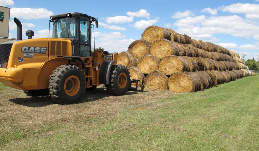 FILE - In this Aug. 22, 2017, file photo, bales of hay that have been donated for a lottery drawing to help drought-stricken farmers and ranchers are stacked at a site near the North Dakota State University campus in Fargo, N.D. North Dakota's Agriculture Department has begun accepting applications from drought-stricken ranchers for $1.5 million in aid to help with hay-hauling costs.The application period runs until Nov. 3. (AP Photo/Dave Kolpack, File)