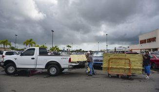 Men load recently purchased wood panels to be used for boarding up windows in preparation for Hurricane Irma, in Carolina, Puerto Rico, Tuesday, Sept. 5, 2017. Irma grew into a dangerous Category 5 storm, the most powerful seen in the Atlantic in over a decade, and roared toward islands in the northeast Caribbean Tuesday. (AP Photo/Carlos Giusti)