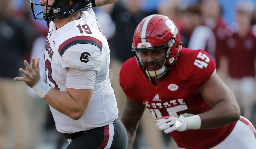 South Carolina's Jake Bentley (19) fires off a pass just before North Carolina State's Darian Roseboro (45) gets the sack during the second half of an NCAA college football game in Charlotte, N.C., Saturday, Sept. 2, 2017. South Carolina won 35-28. (AP Photo/Bob Leverone)