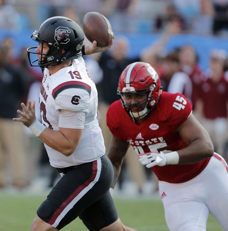 South Carolina's Jake Bentley (19) fires off a pass just before North Carolina State's Darian Roseboro (45) gets the sack during the second half of an NCAA college football game in Charlotte, N.C., Saturday, Sept. 2, 2017. South Carolina won 35-28. (AP Photo/Bob Leverone)
