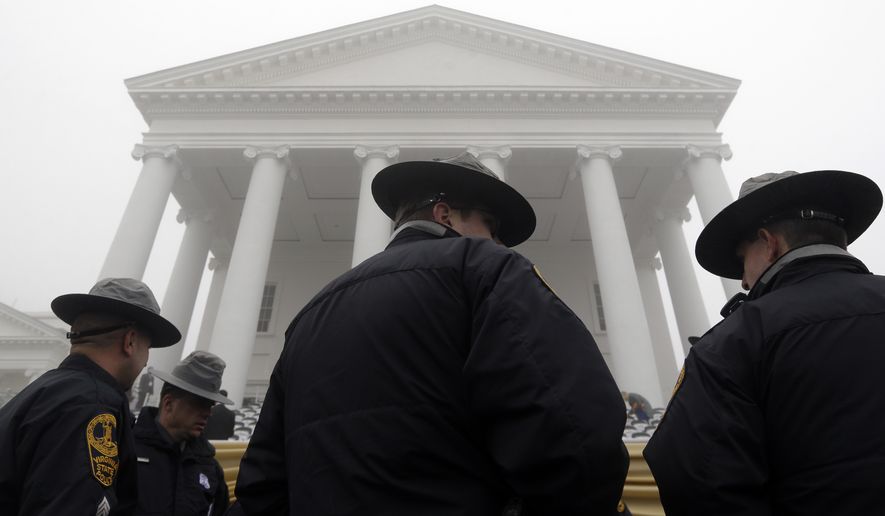 Virginia State Police stand outside the Virginia State Capitol as fog envelopes the area before inaugural ceremonies for Governor-elect Terry McAuliffe in Richmond, Va., Saturday, Jan. 11, 2014. (Associated Press) **FILE**