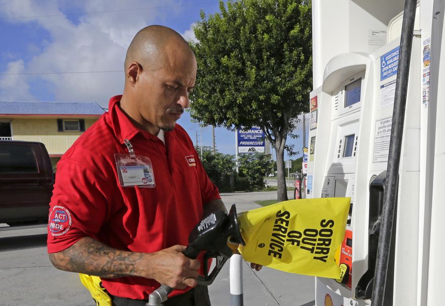 Gas station employee Albert Fernandez covers a pump after running out of gas as the demand for gas has increased due to Hurricane Irma, Wednesday, Sept. 6, 2017, in Key Largo, Fla. Irma roared into the Caribbean with record force early Wednesday, its winds shaking homes and flooding buildings on a chain of small islands along a path toward Puerto Rico, the Dominican Republic, Haiti, Cuba and likely Florida by the weekend. (AP Photo/Alan Diaz)