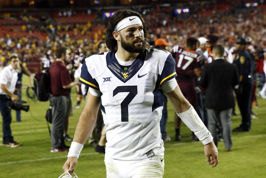 FILE - In this Sept. 3, 2017, file photo, West Virginia quarterback Will Grier walks off the field after after a 31-24 loss in an NCAA college football game against Virginia Tech, in Landover, Md. West Virginia and Texas, both in the Top 25 to start this season, lost the Big 12’s only opening-weekend games against other Power Five leagues. (AP Photo/Patrick Semansky, File)