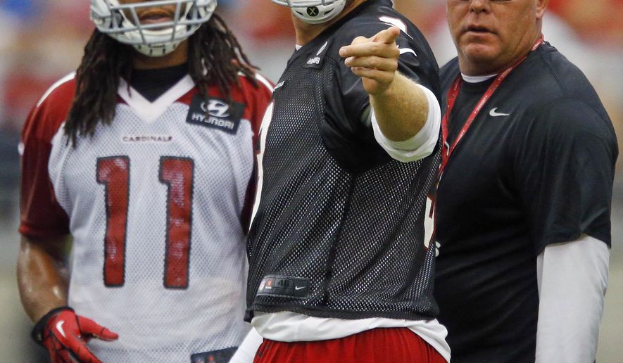 FILE - This July 27, 2013 file photo shows Arizona Cardinals' Larry Fitzgerald, left, and Carson Palmer talking with with coach Bruce Arians during NFL football training camp in Glendale, Ariz. Maybe this is the last go-round for the aging Arizona Cardinals trio of Arians, Palmer and Fitzgerald. At least one of them might call it quits after this season. If it’s their last year together, they are convinced they are part of a team that has the talent to contend. (David Kadlubowski/The Arizona Republic via AP, file)