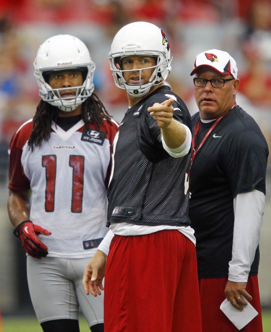 FILE - This July 27, 2013 file photo shows Arizona Cardinals' Larry Fitzgerald, left, and Carson Palmer talking with with coach Bruce Arians during NFL football training camp in Glendale, Ariz. Maybe this is the last go-round for the aging Arizona Cardinals trio of Arians, Palmer and Fitzgerald. At least one of them might call it quits after this season. If it’s their last year together, they are convinced they are part of a team that has the talent to contend. (David Kadlubowski/The Arizona Republic via AP, file)
