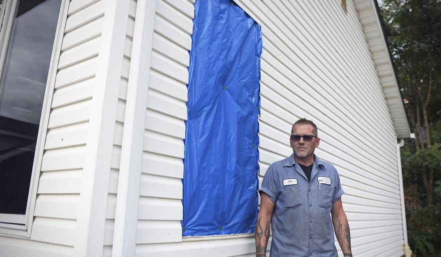 In this Thursday, Aug. 24, 2017 photo, Jim Cool poses for a photo near the window of his garage that was shattered by thefts in Akron, Ohio. The culprits stole two dirt bikes and a four wheeler from Cool's garage. (Leah Klafczynski/Akron Beacon Journal via AP)