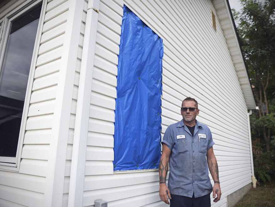 In this Thursday, Aug. 24, 2017 photo, Jim Cool poses for a photo near the window of his garage that was shattered by thefts in Akron, Ohio. The culprits stole two dirt bikes and a four wheeler from Cool's garage. (Leah Klafczynski/Akron Beacon Journal via AP)