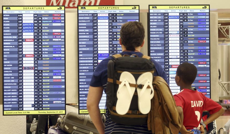 Passengers check the departure board at Miami International Airport Thursday, Sept. 7, 2017. South Florida officials are expanding evacuation orders as Hurricane Irma approaches, telling more than a half-million people to seek safety inland. (AP Photo/Marta Lavandier)