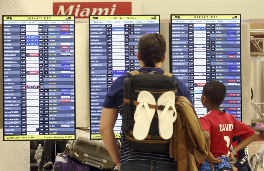 Passengers check the departure board at Miami International Airport Thursday, Sept. 7, 2017. South Florida officials are expanding evacuation orders as Hurricane Irma approaches, telling more than a half-million people to seek safety inland. (AP Photo/Marta Lavandier)