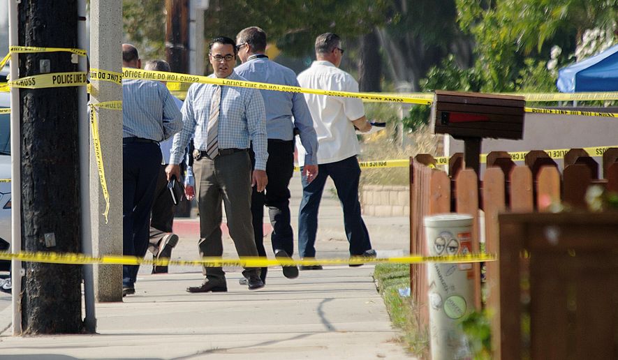 A detective stops for a moment to look again at the scene where two officers and one suspect were hospitalized after a call for a man with a knife turned into an officer-involved shooting in Huntington Beach, Calif., Thursday, Sept. 7, 2017. (Ken Steinhardt/The Orange County Register via AP)