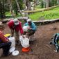 ADVANCE FOR USE SATURDAY, SEPT. 9 - In this July 29, 2017 photo,Mary Lundin, Francesca Watts, Joe Lavorini from left, clean water filters after a day of trail building with the Rocky Mountain Field Institute in Crestone, Colo. If all goes according to plan, the Colorado Springs-based nonprofit will wrap up its arduous effort to build the mile-long reroute to the 14,170-foot summit of Kit Carson Peak by the end of this month. The trail is set to be finished thanks to a compilation of grants and a hearty bunch of 20-somethings from around the country. (Doug Brownlie/The Gazette via AP)