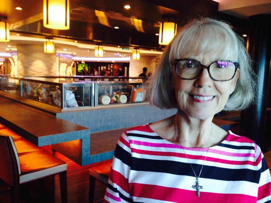 In this Thursday, Sept. 7, 2017 photo, Margaret Cunningham, of Battle Ground, Wash., poses aboard the Norwegian Escape cruise ship, shortly before the huge vessel returned to port in Miami, two days early due to Hurricane Irma. Cunningham and her husband, Mike, were staying aboard the ship, which was headed to safe waters that evening. While it was unknown when or where the ship would return due to the powerful storm, Cunningham said she is assured the ship will be a safe and heavily-supplied haven at sea. (AP Photo/Brian Witte)