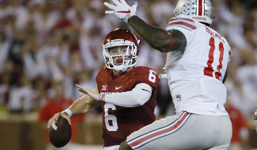 FILE - In this Sept. 17, 2016, file photo, Oklahoma quarterback Baker Mayfield (6) is pressured by Ohio State defensive end Jalyn Holmes (11) during an NCAA college football game in Norman, Okla. Mayfield clearly recalls the nightmare that transpired in Norman last year when Ohio State came to town a year ago. (AP Photo/Sue Ogrocki, File)
