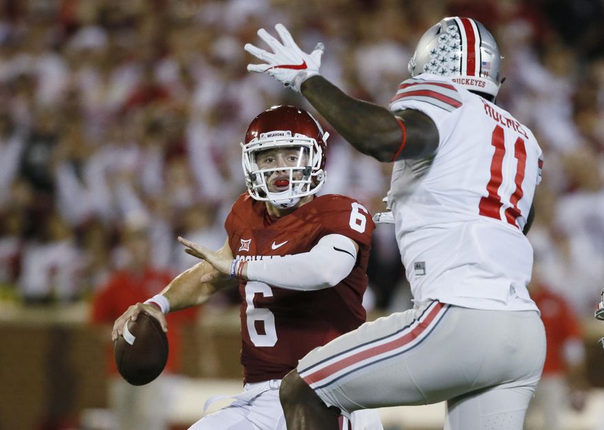 FILE - In this Sept. 17, 2016, file photo, Oklahoma quarterback Baker Mayfield (6) is pressured by Ohio State defensive end Jalyn Holmes (11) during an NCAA college football game in Norman, Okla. Mayfield clearly recalls the nightmare that transpired in Norman last year when Ohio State came to town a year ago. (AP Photo/Sue Ogrocki, File)