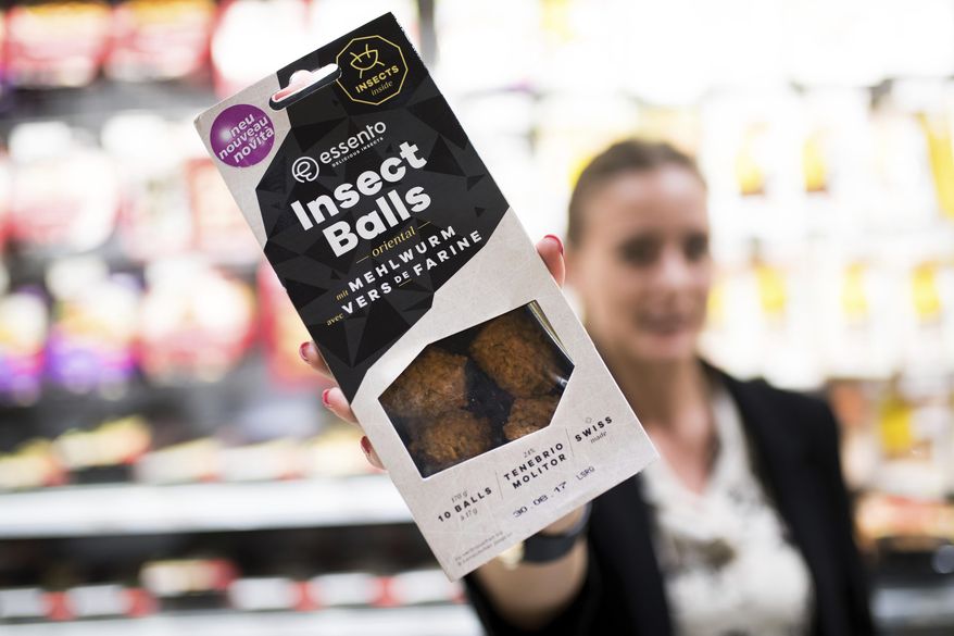 FILE - In this Aug. 21, 2017 file photo an employee of a Coop supermarket shows a packet of insect balls in Lugano, Switzerland. Swiss supermarket chain Coop, to a bit of hoopla, began selling “burgers” and “balls” made from insects. It’s billed as a first in Europe, a continent more accustomed to steak, sausage, poultry and fish as a source of protein rather than bugs that can be found in places like Africa or Asia. (Gabriele Putzu/Ti-Press/Keystone via AP, file)