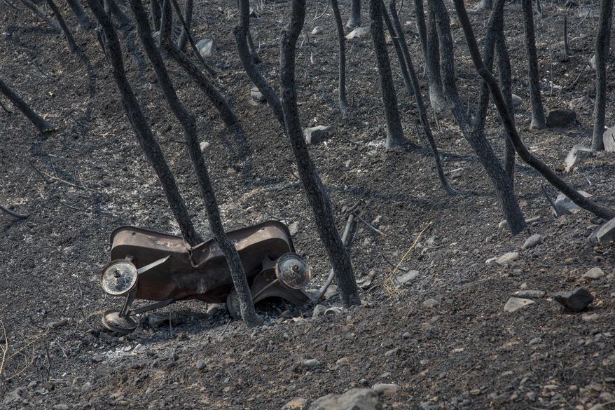 A toy wagon leans against dead brush off of Bybee Dr. in Weber County in the aftermath of the Uintah Fire on Wednesday, Sept. 6, 2017. Most of the homes along Bybee were undamaged in the fire, but several houses were destroyed. (Benjamin Zack/Standard-Examiner via AP)