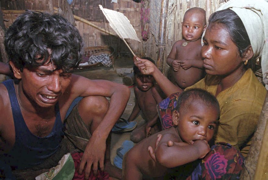 FILE - In this July 26, 1997, file photo, Mohammad Hamid breaks into tears before his wife, Halima, and their children in Nayapara refugee camp near the border town of Teknaf, 320 kilometers (about 200 miles) southeast Dhaka, Bangladesh. Hamid and his family along with about 21,000 Burmese refugees refused to return home in Burma. Myanmar's Rohingya Muslims have been called the world's most persecuted minority, a people without a country. Recently, in numbers estimated to be nearing 300,000, Rohingya have been fleeing for their lives into already-crowded refugee camps in neighboring Bangladesh. It is the third such mass exodus in four decades. (AP Photo/Pavel Rahman, File)