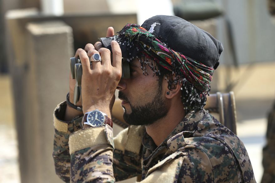 An Arab fighter with U.S.-backed Syrian Democratic Forces keeps watch during coalition airstrikes against Islamic State. With Syrian government forces besieging Raqqa on another front, an SDF military commander this week told The Associated Press that the fight to retake the Islamic State stronghold was "in its final stages." (Associated Press/File)