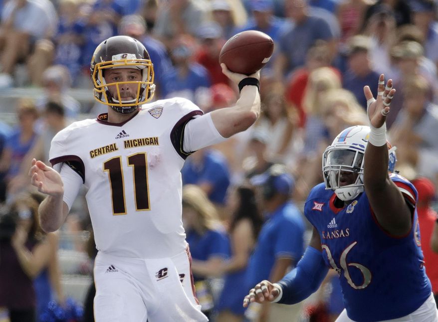 Central Michigan quarterback Shane Morris (11) throws under pressure from Kansas defensive tackle Daniel Wise (96) during the first half of an NCAA college football game, Saturday, Sept. 9, 2017, in Lawrence, Kan. (AP Photo/Charlie Riedel)